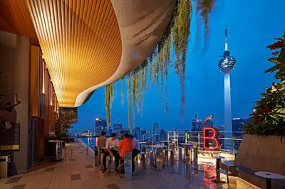people sitting at tables in a restaurant with a view of the city at Ceylonz Suites in Kuala Lumpur