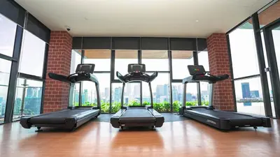 a gym with four exercise bikes in a room with windows at Ceylonz Suites in Kuala Lumpur