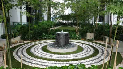 a garden with a fountain in the middle of a building at MCity Ampang, KL in Kuala Lumpur