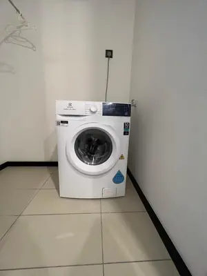 a washing machine sitting in a corner of a room at Opus Residences KL Malaysia in Kuala Lumpur