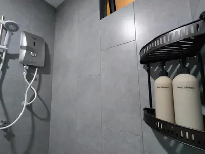 a bathroom with a rack with three white bottles at M Vertica By Minsu in Kuala Lumpur