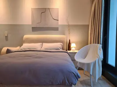a bedroom with a large bed and a chair at M city service suite KLCC in Kuala Lumpur