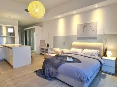 a bedroom with a large bed and a kitchen at M city service suite KLCC in Kuala Lumpur