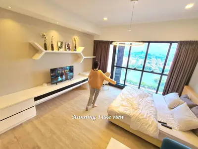 a woman standing in a living room looking out the window at M city service suite KLCC in Kuala Lumpur