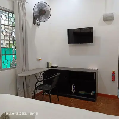 a room with a table and a television and a chair at Cheras Homestay Family room with Private Bathroom in Kuala Lumpur