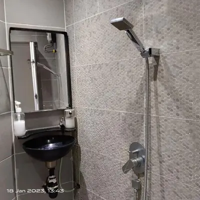 a bathroom with a sink and a shower with a mirror at Cheras Homestay Family room with Private Bathroom in Kuala Lumpur