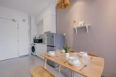 a kitchen with a wooden table with dishes on it at Muji Home 2BR 4Pax Southlink Nexus Bangsar South in Kuala Lumpur