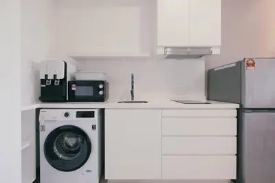 a kitchen with a washing machine and a microwave at Muji Home 2BR 4Pax Southlink Nexus Bangsar South in Kuala Lumpur