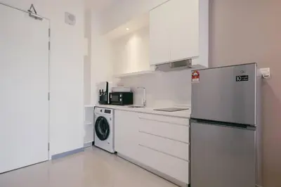 a kitchen with a refrigerator and a washing machine at Muji Home 2BR 4Pax Southlink Nexus Bangsar South in Kuala Lumpur
