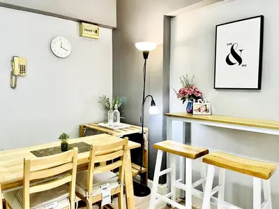 a dining room with a table and chairs and a clock at Suasana Stay & Homestay Sentul Utama Kuala Lumpur 3R3BR 2AC 2 Car park-Netflix-WIFI-Pool View in Kuala Lumpur