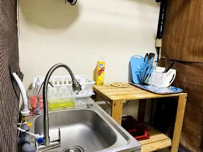 a kitchen counter with a sink and a wooden table at Suasana Stay & Homestay Sentul Utama Kuala Lumpur 3R3BR 2AC 2 Car park-Netflix-WIFI-Pool View in Kuala Lumpur