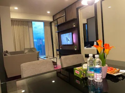 a room with a table with flowers and a living room at Tropicana The Residences By RS in Kuala Lumpur