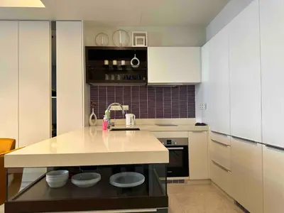 a kitchen with white cabinets and a counter top at Tropicana The Residences By RS in Kuala Lumpur