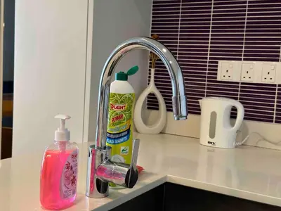 a sink with a bottle of mouthwash next to a faucet at Tropicana The Residences By RS in Kuala Lumpur