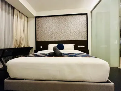 a bed with a person laying on top of it at Tropicana The Residence Klcc By Sky World in Kuala Lumpur