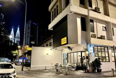 a building with tables and chairs on a city street at night at #23 KL towel view twin bed suites @ infinity pool in Kuala Lumpur