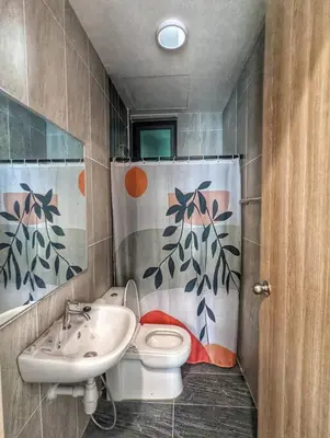 a bathroom with a sink and a toilet and a shower curtain at Legasi 3-bedroom condo - 5 mins walk to KLCC in Kuala Lumpur