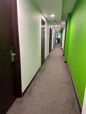 a corridor of a hallway with green walls and a long hallway at Uptown Chinatown in Kuala Lumpur