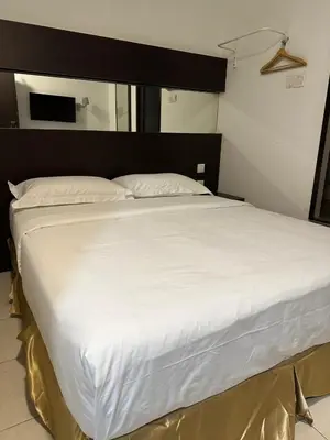 a large white bed with a black headboard at Uptown Chinatown in Kuala Lumpur