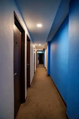 an empty corridor with blue walls and a hallway with a hallway at Uptown Chinatown in Kuala Lumpur