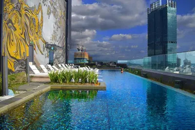 a swimming pool on the roof of a building with chairs at Star Sky Park KLCC in Kuala Lumpur