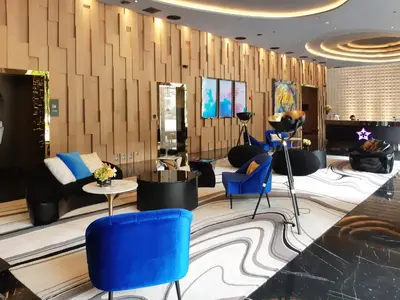 a lobby with blue chairs and a table and a salon at Star Sky Park KLCC in Kuala Lumpur