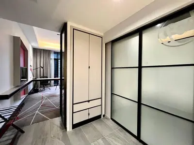a room with a closet with glass doors and a desk at #211 M101 Dang Wangi KLCC View Pool By Livin in Kuala Lumpur