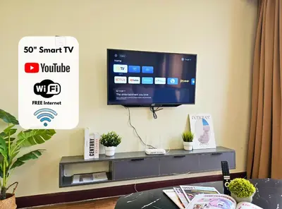 a flat screen tv on a wall in a living room at Homestay Heart of Bukit Bintang Walk to Monorail & LRT St by Cloud Host in Kuala Lumpur