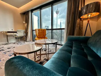 a living room with a green couch and tables at The Platinum 2 Kuala Lumpur by HOLMA in Kuala Lumpur