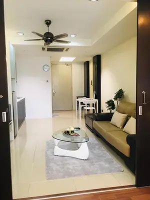 a living room with a couch and a table at Kuala Lumpur Bukit Bintang LaLaport Serviced Suite KLCC in Kuala Lumpur