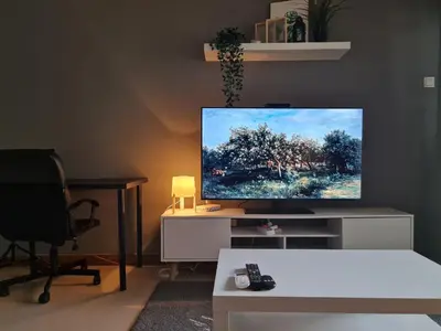 a flat screen tv sitting on a white entertainment center at 1 min Next to LRT CHERAS 68 with Shared Area in Kuala Lumpur
