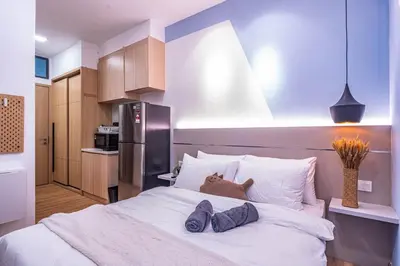 a dog laying on a bed in a bedroom at The Colony By Infinitum Best Pool View KLCC TRX Merdeka 118 KL Tower in Kuala Lumpur