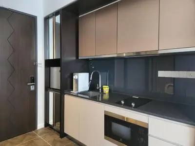 a kitchen with brown cabinets and a black counter top at Infini Suites@ Scarletz Suites KLCC in Kuala Lumpur