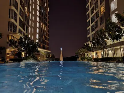 a large swimming pool at night with buildings at Orion Suites@ The Robertson Bukit Bintang in Kuala Lumpur