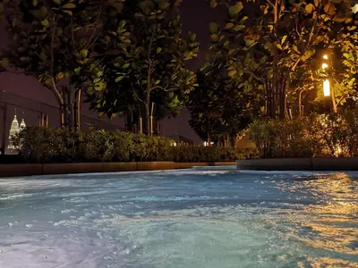 a swimming pool at night with trees and lights at Orion Suites@ The Robertson Bukit Bintang in Kuala Lumpur
