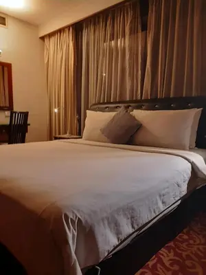 a bedroom with a large bed with white sheets and pillows at Times Square East privite service Apartment in Kuala Lumpur