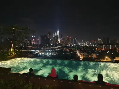 a group of people sitting in a swimming pool at night at Studio near KLCC and LRT with superb view in Kuala Lumpur