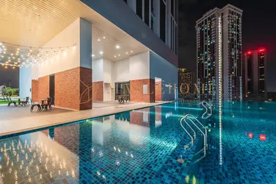 a large swimming pool in a city at night at Chambers Premier Suites Kuala Lumpur in Kuala Lumpur