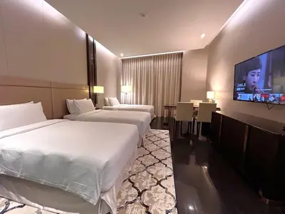 a hotel room with two beds and a flat screen tv at Atelier Bukit Bintang in Kuala Lumpur