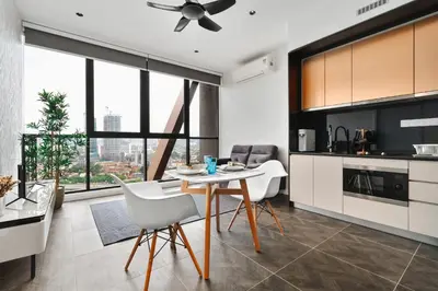 a kitchen with a table and chairs and a ceiling fan at Scarletz KLCC Apartments by soulasia in Kuala Lumpur