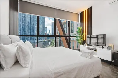 a bedroom with a white bed and a large window at Scarletz KLCC Apartments by soulasia in Kuala Lumpur