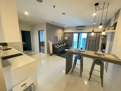 a kitchen and living room with a table and a couch at Mercu Summer Suite KLCC by Minshuku in Kuala Lumpur