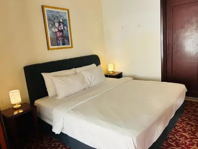 a bedroom with a large white bed with two night stands at MN SUITE At TIMES SQUARE KL in Kuala Lumpur