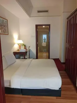 a bedroom with a large white bed and a table at MN SUITE At TIMES SQUARE KL in Kuala Lumpur