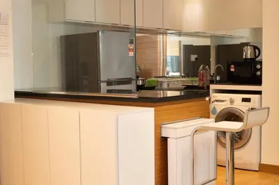 a kitchen with a washing machine and a washer at Dua Sentral Residence near KL Sentral by COBNB in Kuala Lumpur