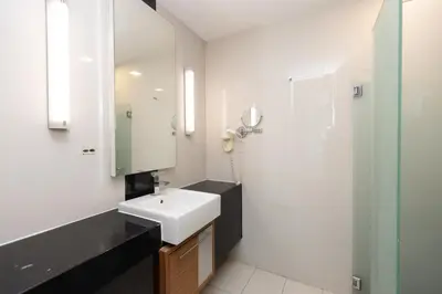 a bathroom with a white sink and a mirror at Dua Sentral Residence near KL Sentral by COBNB in Kuala Lumpur