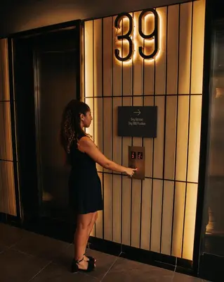 a woman is standing in front of an elevator at Ceylonz KLCC by Mana-Mana in Kuala Lumpur