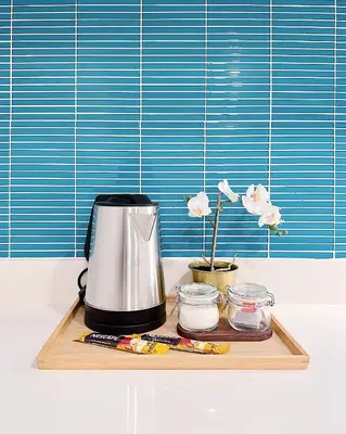 a coffee maker on a wooden cutting board with flowers at Tropicana The Residence LV Suite with KLCC View in Kuala Lumpur