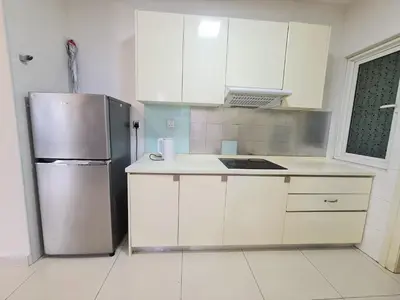 a kitchen with white cabinets and a stainless steel refrigerator at Crest Residence Klcc by Sarah's Lodge in Kuala Lumpur
