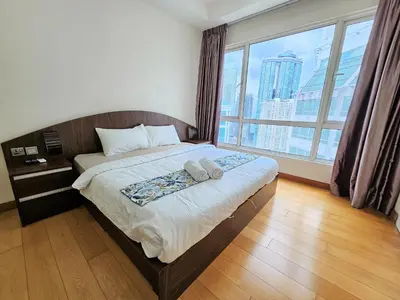 a bedroom with a bed with a large window at Crest Residence Klcc by Sarah's Lodge in Kuala Lumpur